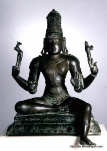 A seated Shiva holds an axe and deer in his hands.